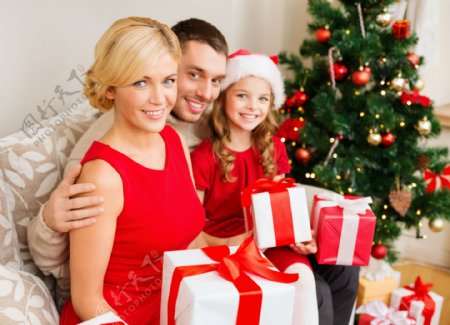 拿着礼物的家庭与圣诞树