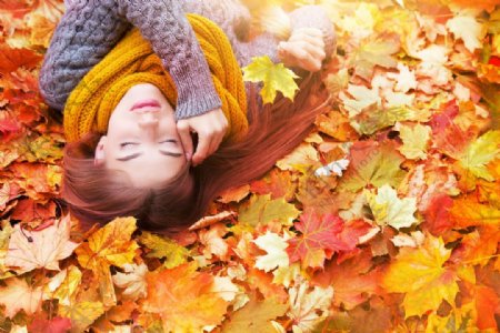 睡在秋天树叶上的美女图片