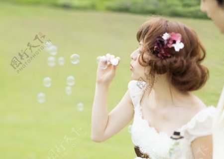 草坪上的新娘在吹泡泡图片