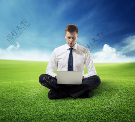 草地打电脑的男人图片