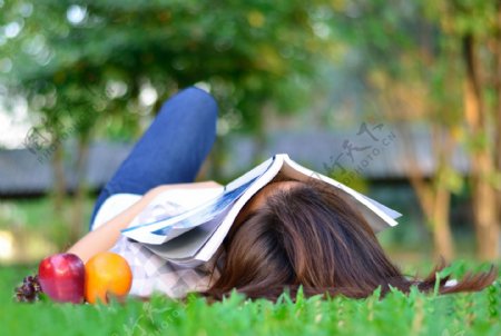 睡在草地上看书的美女图片