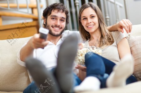 坐在沙发上看电视的外国情侣图片