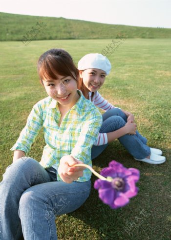 坐在草地上的两个休闲美女图片