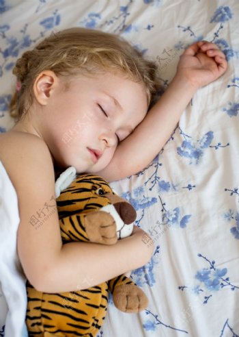 抱着玩具睡觉的小女孩图片