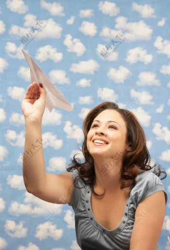 蓝天下玩纸飞机的美女图片