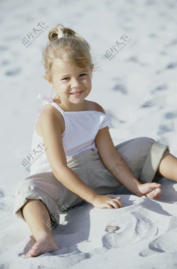 沙滩上玩沙子的小女孩图片