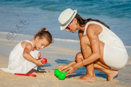 海边一起玩沙的母女图片