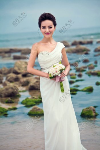 大海边手拿鲜花的新娘图片