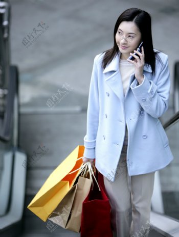 拎着个购物袋打电话的时尚女性图片图片