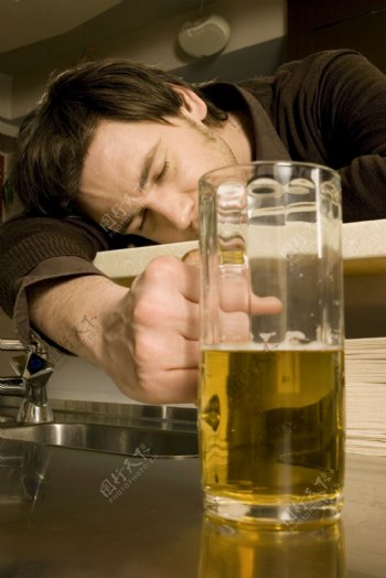 手拿啤酒睡着的男人图片